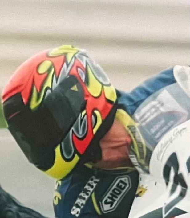 Primer plano de casco amarillo y rojo con llamas
