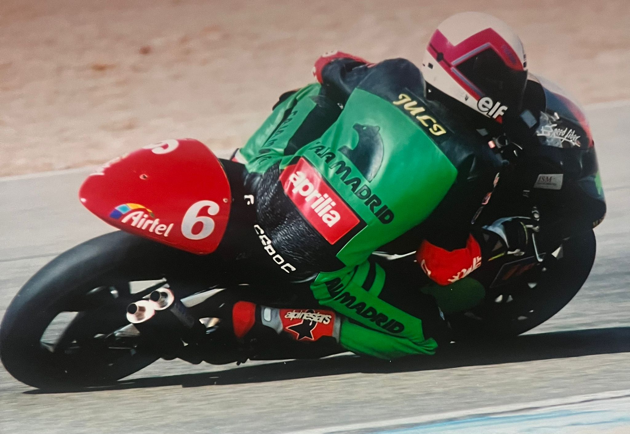 Aprilia número 6 verde y rojo inclinada en curva