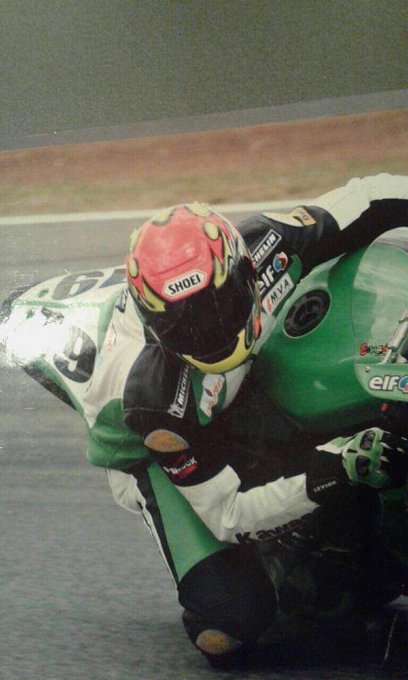Kawasaki número 69 verde corriendo bajo lluvia